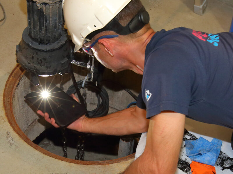 Ein Servicetechniker der Firma Pumpenservice kontrolliert eine Pumpe.